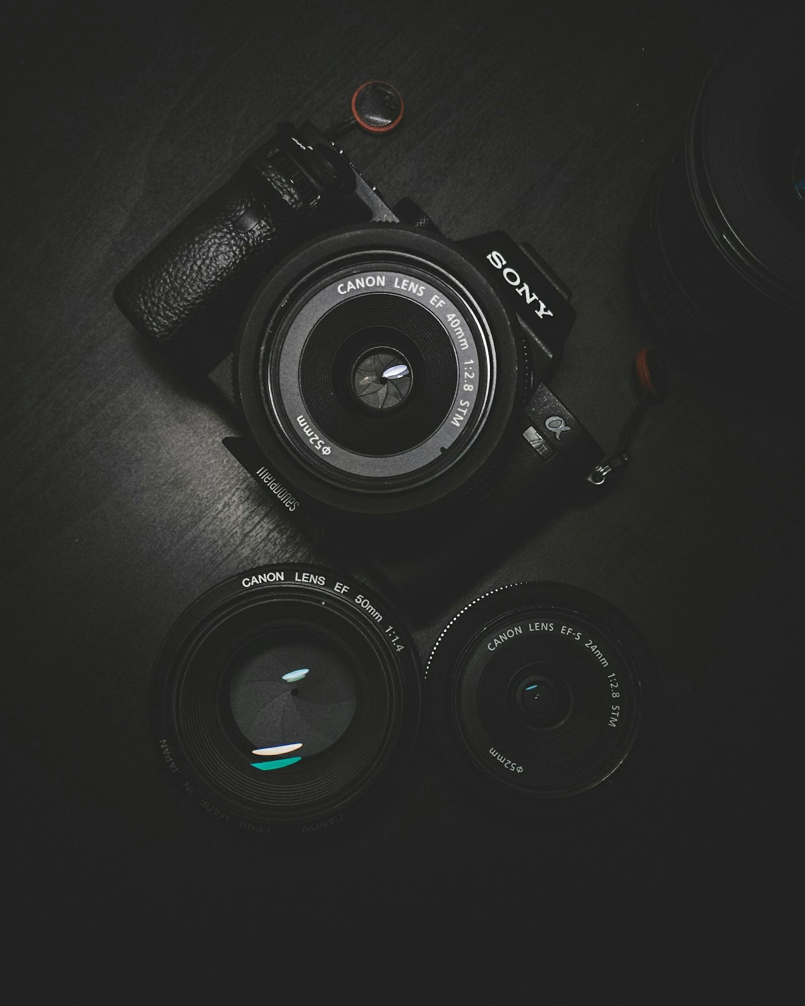 A camera and lenses arranged on a dark surface