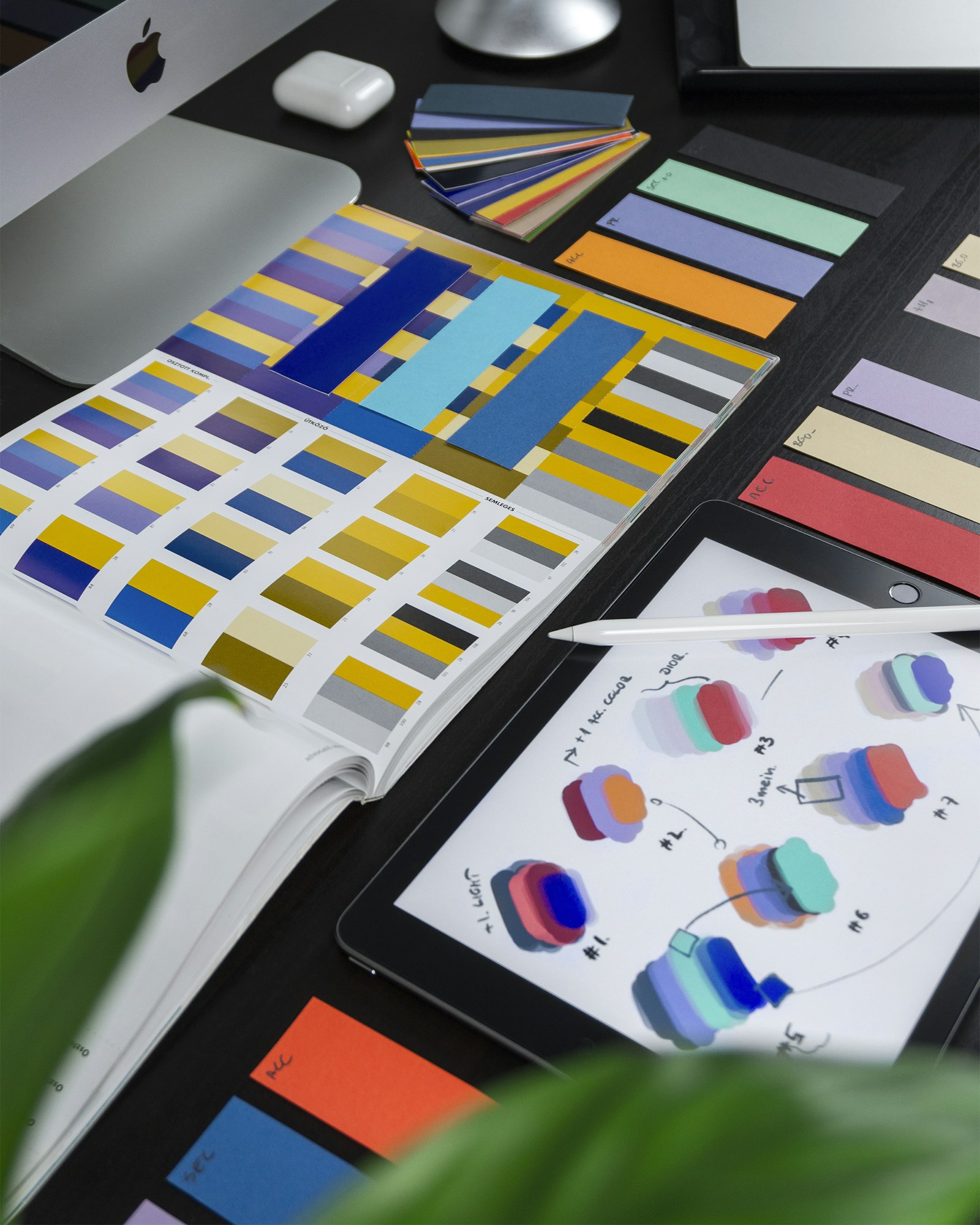 Color swatches and identity design work spread across a designer's desk